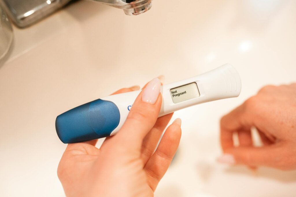 Osoba trzyma w d&Aring;oni test ci&Auml;&Aring;&frac14;owy z wynikiem: not pregnant