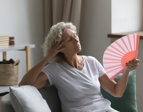 starsza kobieta używająca wachlarza