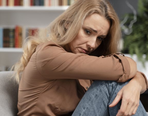zmartwiona kobieta siedząca na kanapie