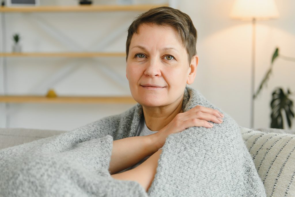 DojrzaÅa kobieta otulajÄ
ca siÄ kocem